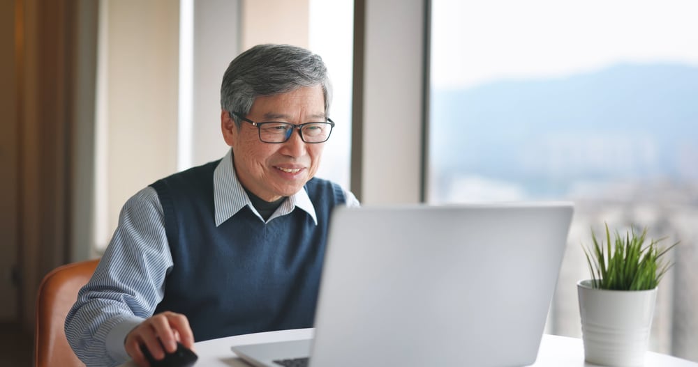 Asian,Senior,Businessman,Use,Laptop,To,Work,Near,Window,At